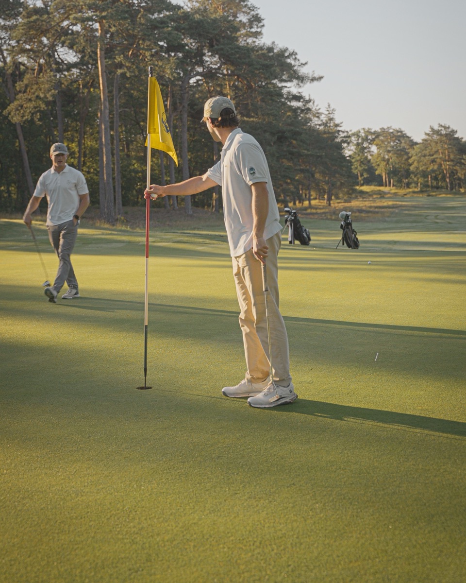 Tending the flag on the green at golden hour