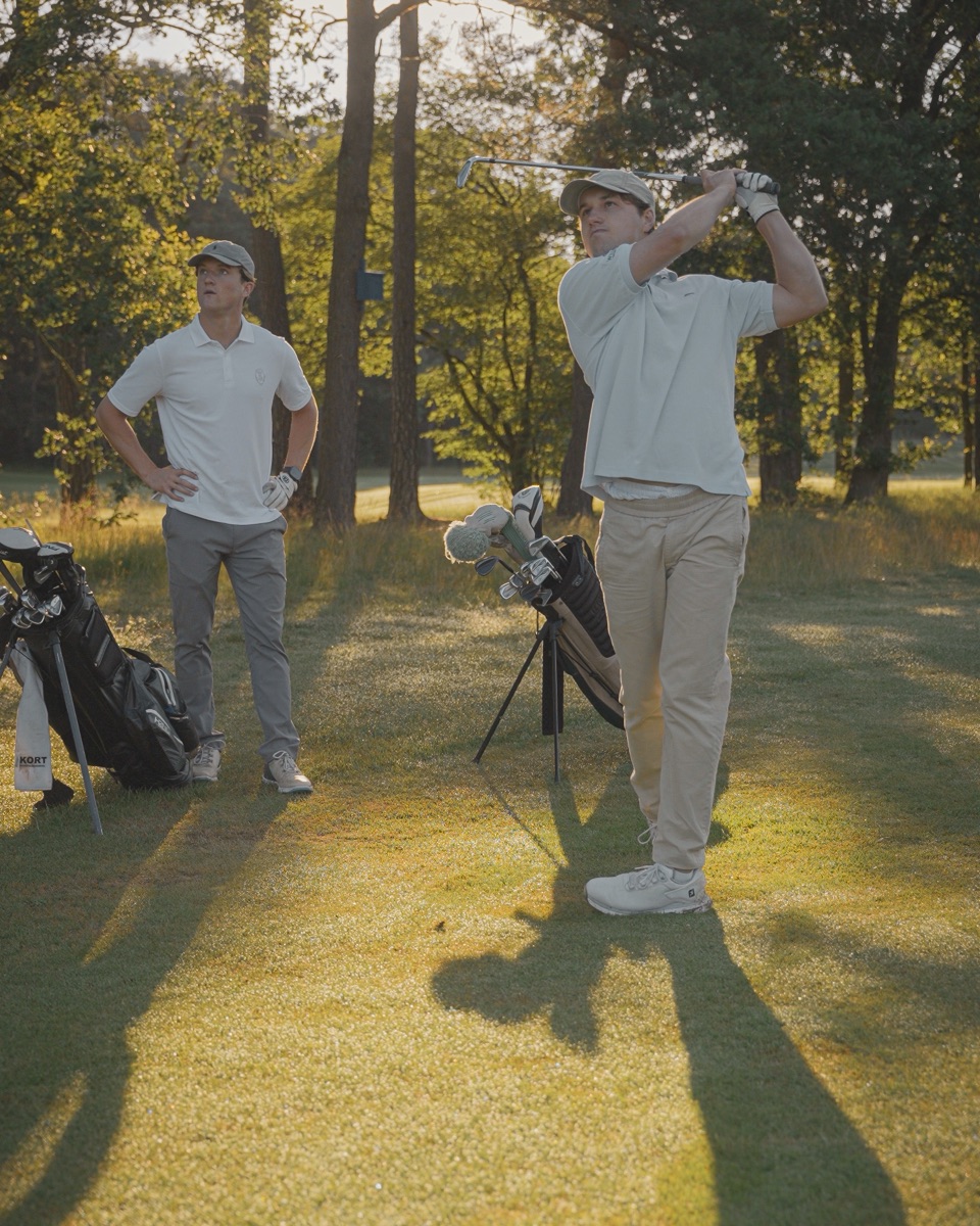 Sergi mid-swing while Guus watches