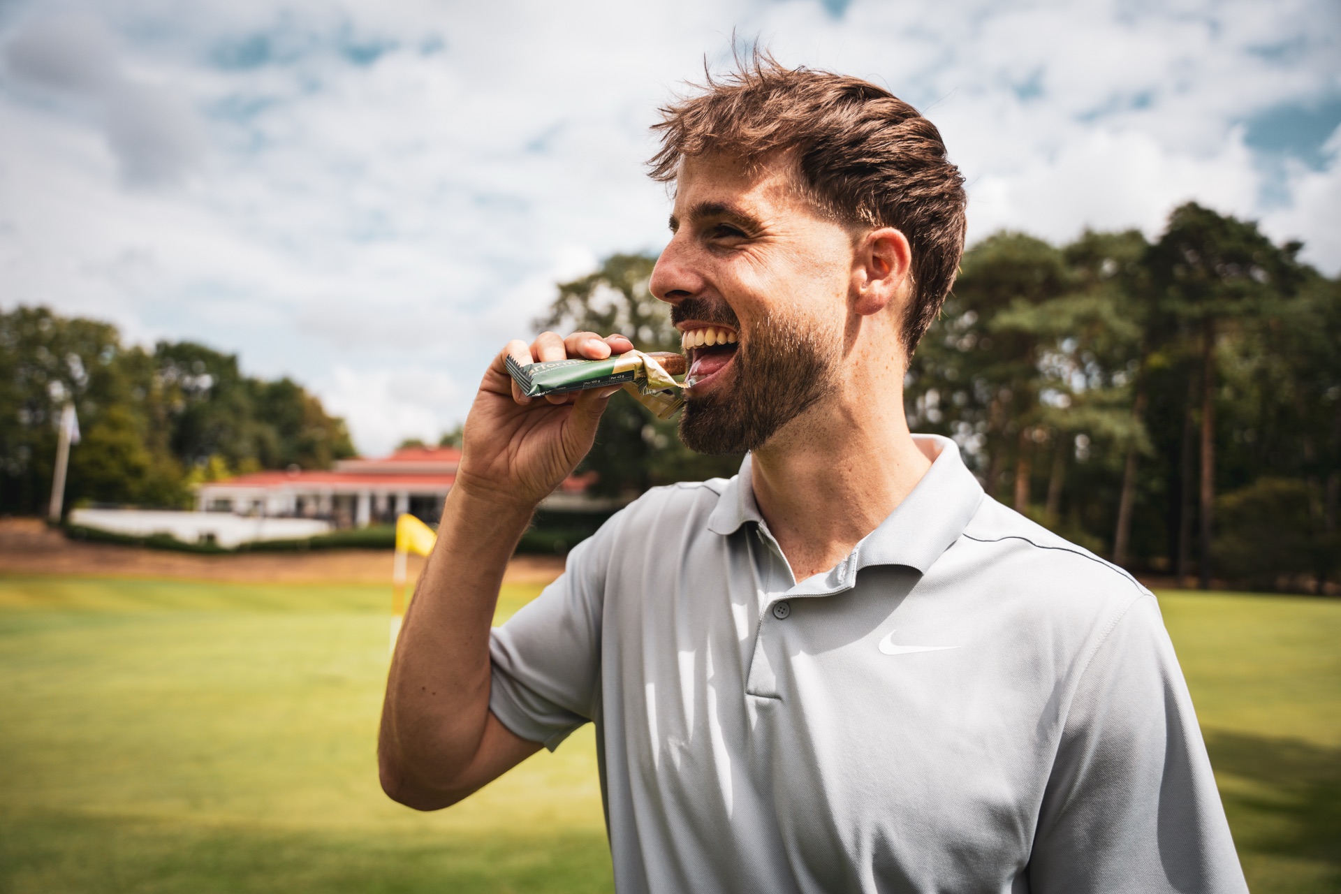 A golfer eating a Parformance Energy Bar on the course